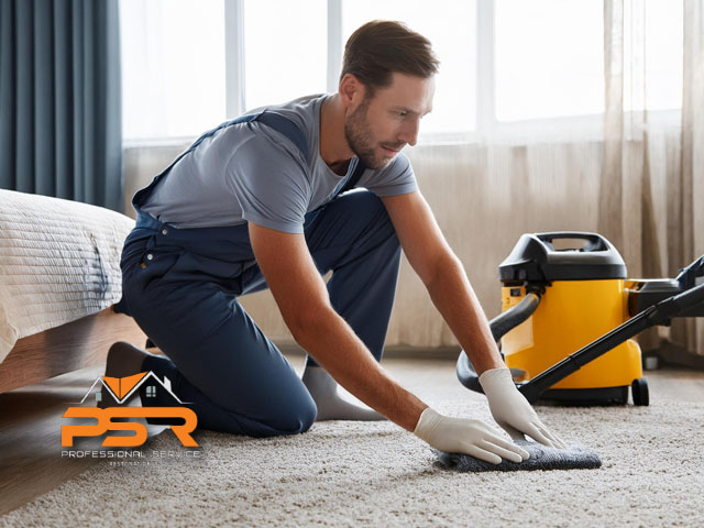 male technician performing professional carpet cleaning in bedroom at home